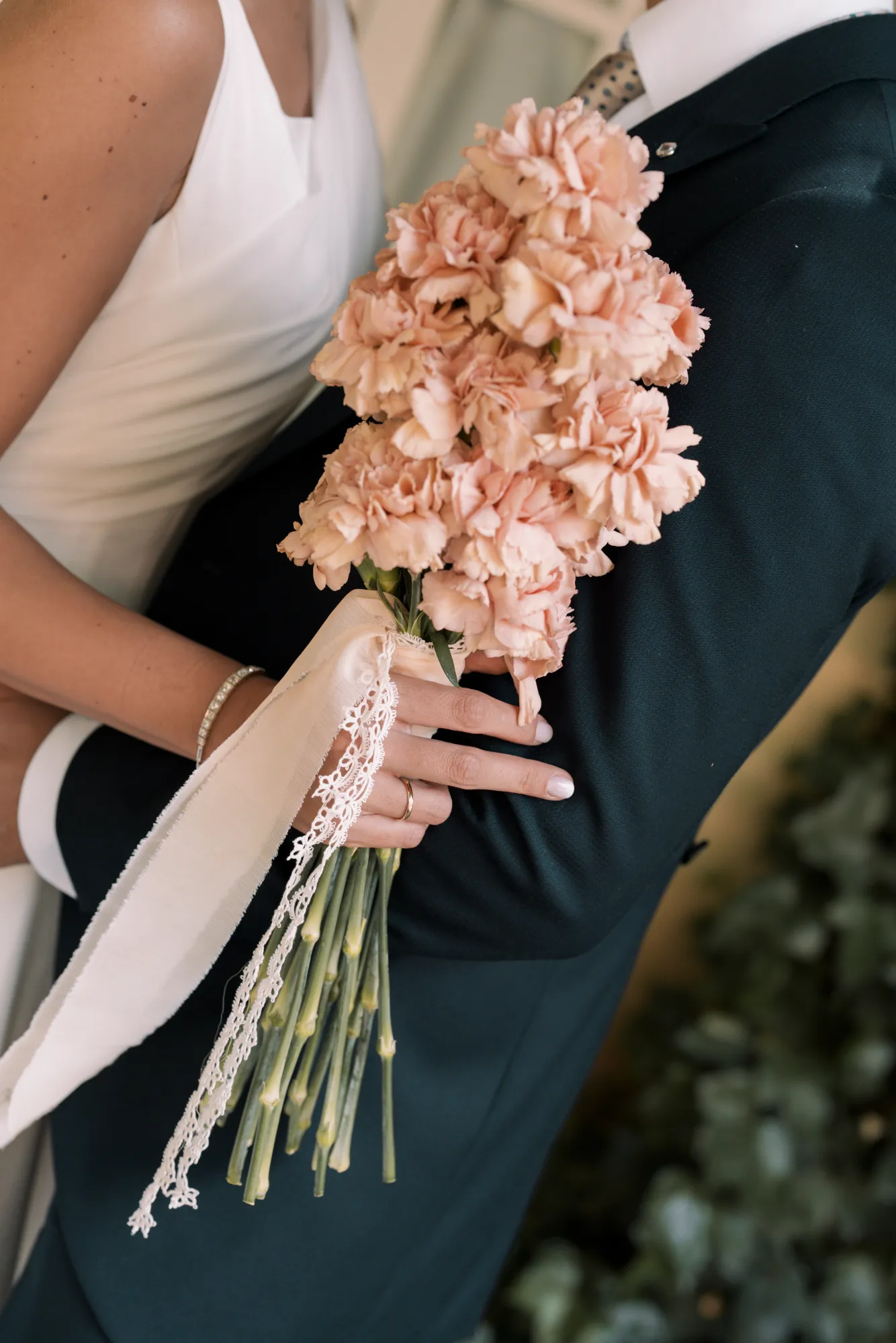 Detalle del ramo de la novia junto al traje del novio