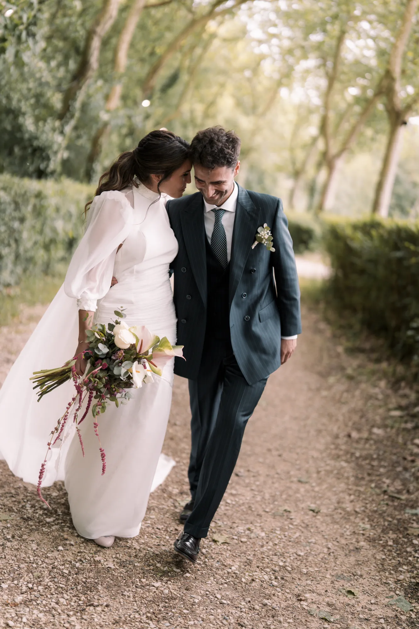 Fotografía de boda: los novios caminan de la mano por un sendero